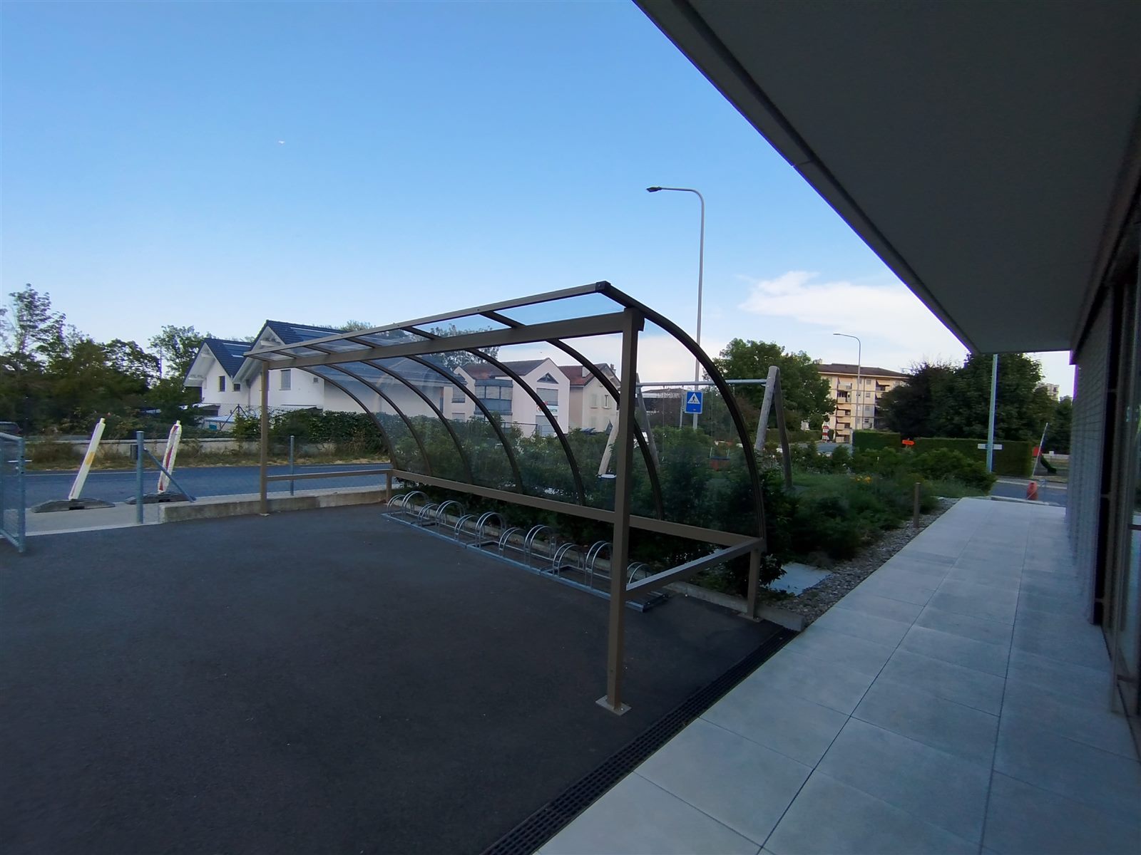 Abri vélo en construction métallique avec toiture cintrée transparente