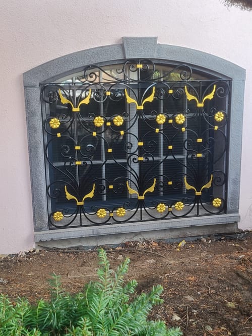Grille de fenêtre en fer forgé, motifs dorés